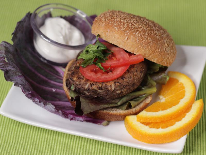 Black Bean Burger with sauce and oranges on the side.