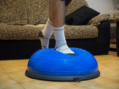 person standing on a bosu ball