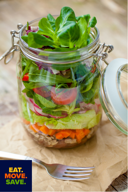 salad ingredients layered in a clear glass jar