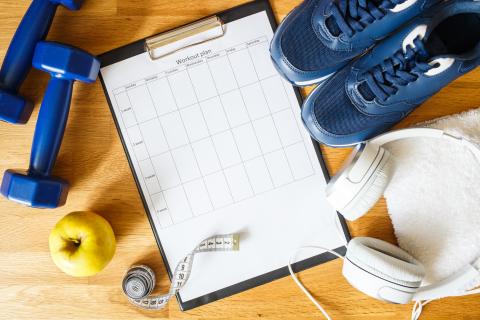 clipboard with a workout plan alongside exercise equipment