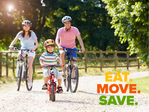 mom, dad and child riding bikes on a gravel road on a sunny day. they are all smiling.