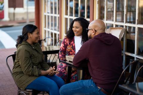 family enjoying a pizza at a table outdoors
