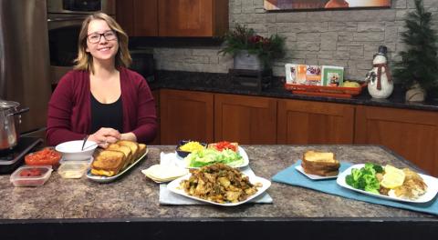 woman stands behind plates of food on a kitchen counter