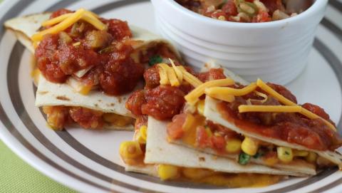 Vegetable Quesadillas topped with salsa and shredded cheese
