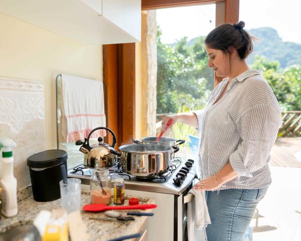 Person stirring food in a pot on the stove.