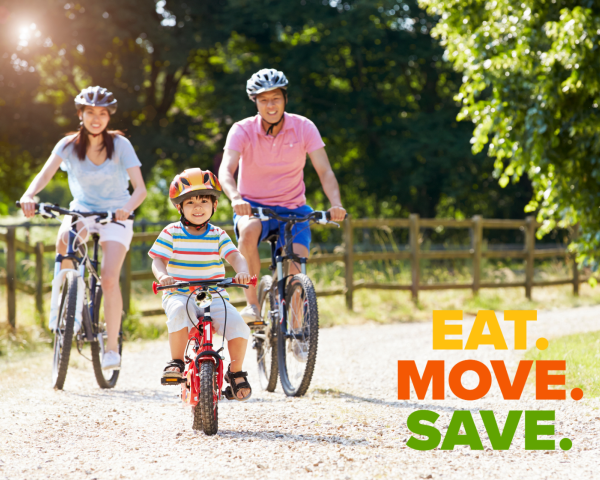 mom, dad and child riding bikes on a gravel road on a sunny day. they are all smiling.