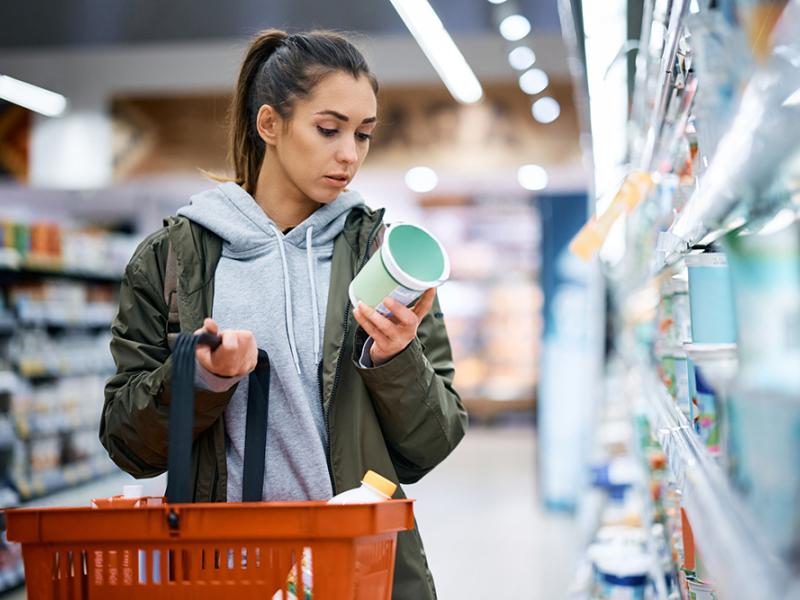 Woman looking at label on package in grocery store