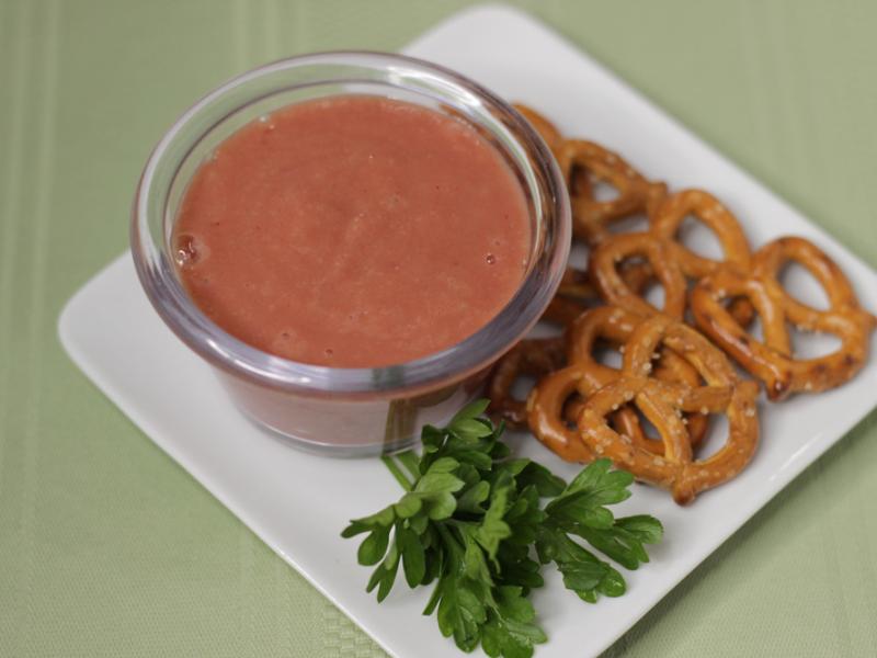 bowl of cranberry mustard dip served alonside pretzels