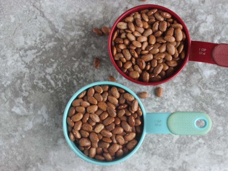two measuring cups full of dried beans