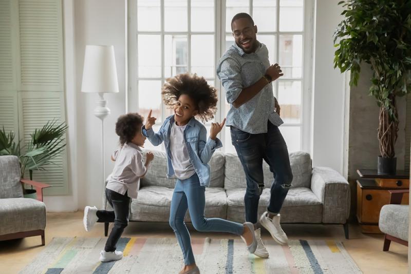 2 kids and dad dancing in living room