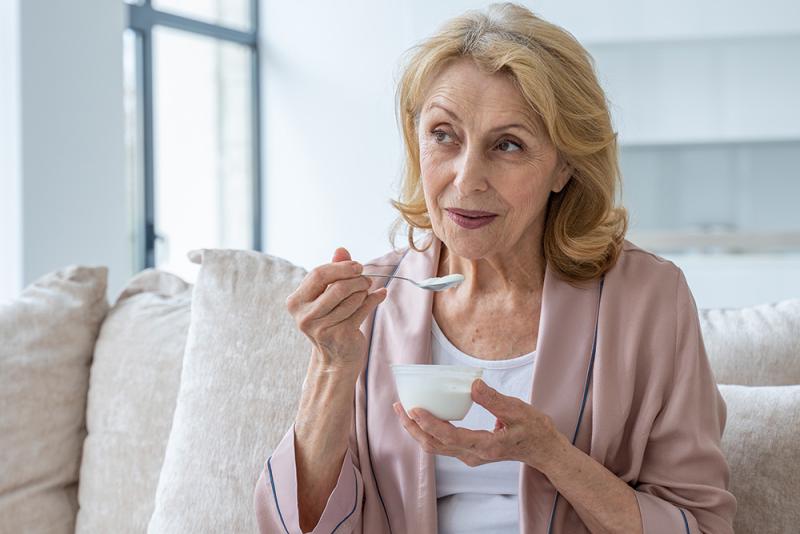 woman eating yogurt sitting on couch