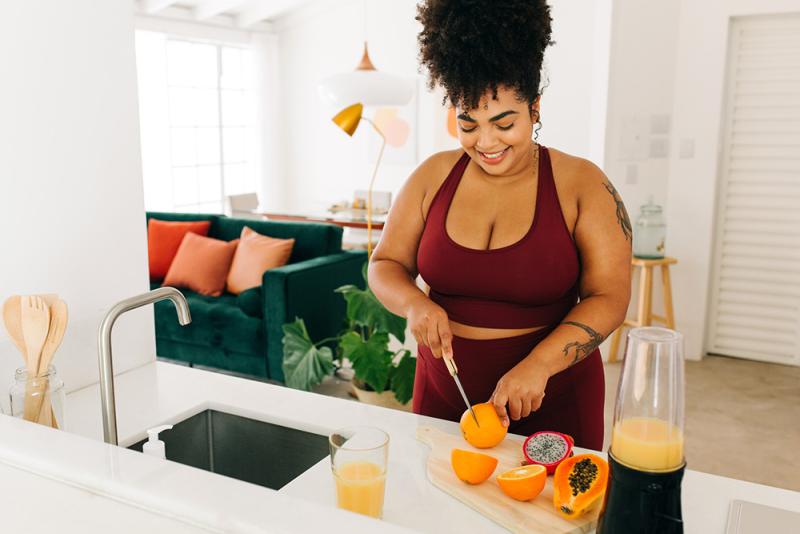 woman cutting up fruit to make juice