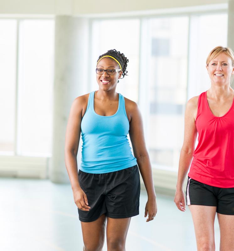 2 women walking on indoor track