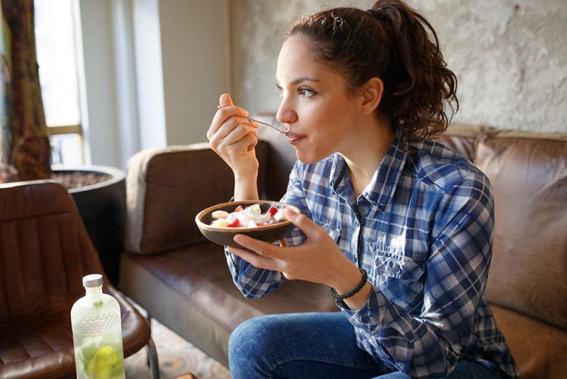 woman eating bowl of cereal