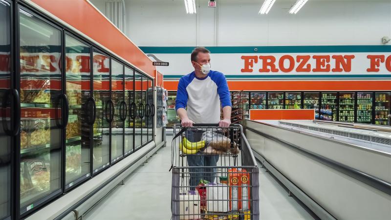 man with a shopping cart in the frozen foods department