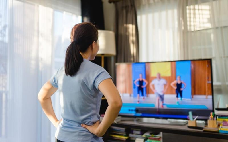 woman standing in front of TV doing an excercise video
